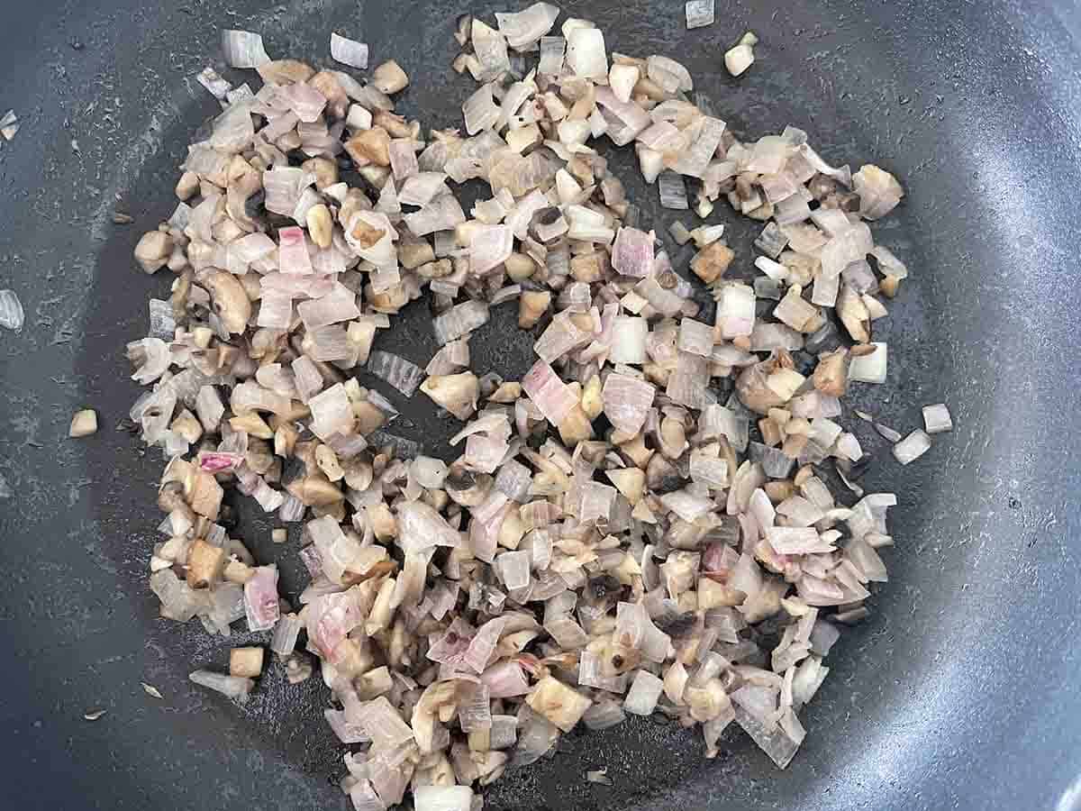 chopped shallots frying in a pan.