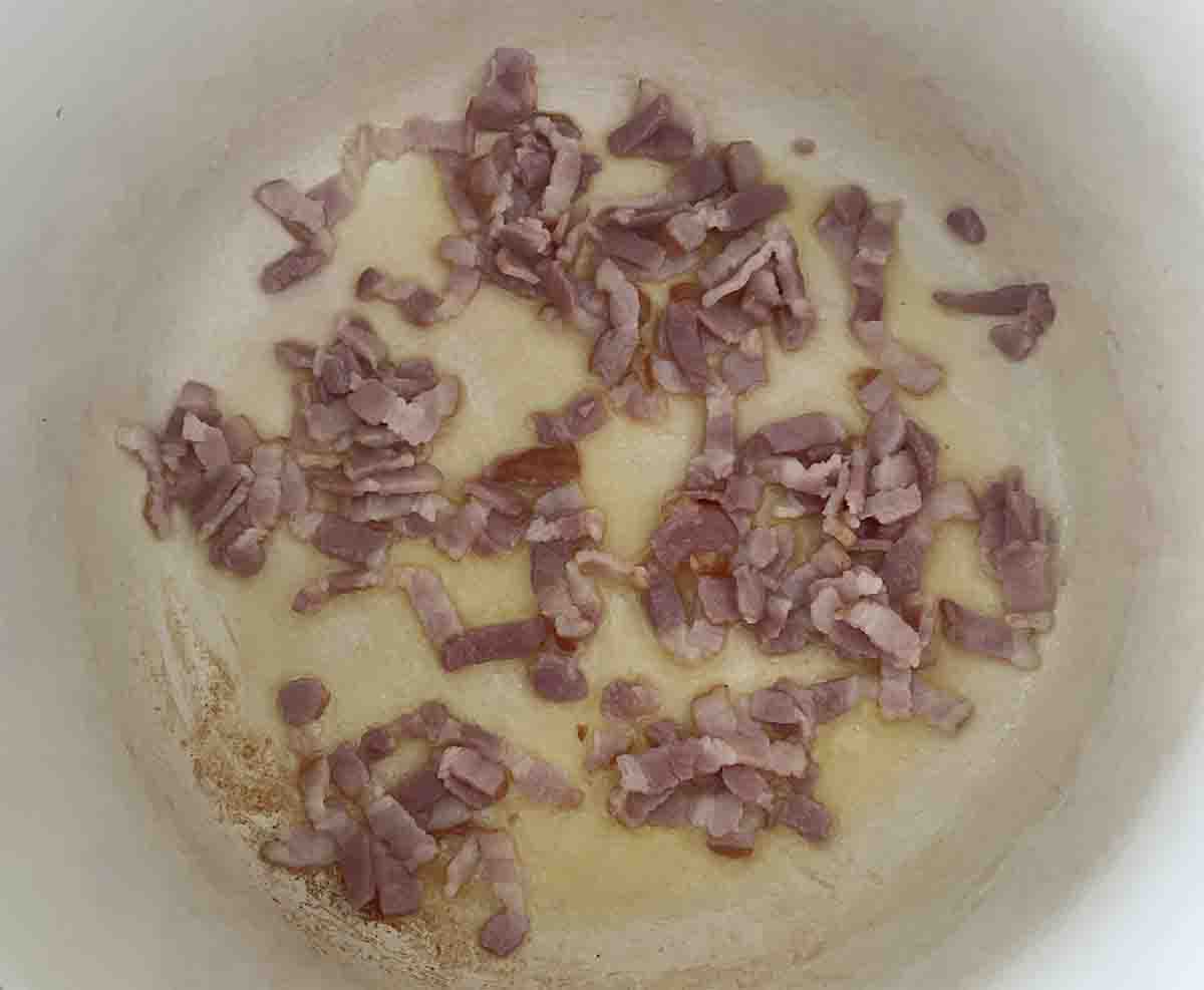 bacon frying in a saucepan.