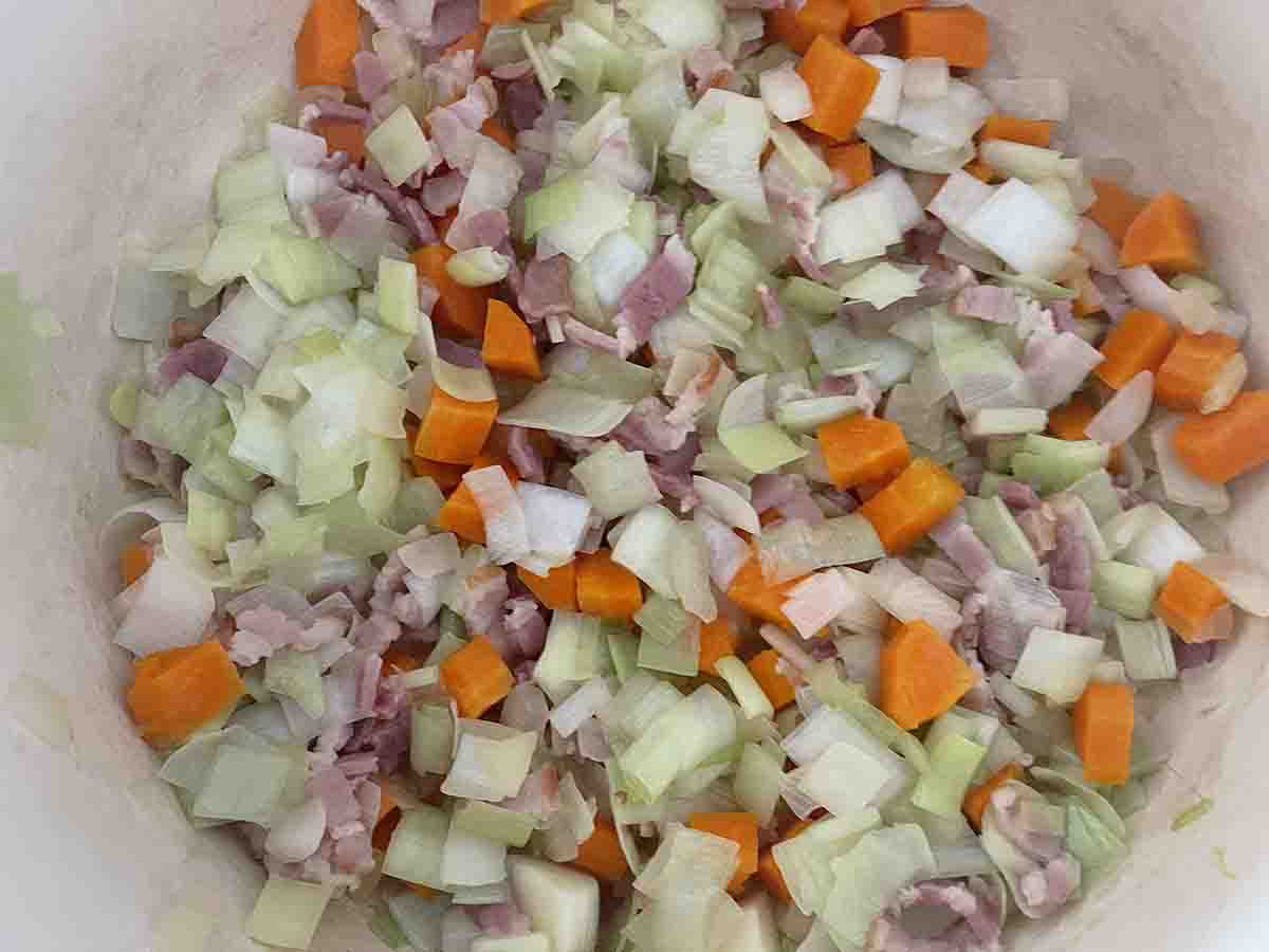 bacon mixed with vegetables frying in the saucepan.