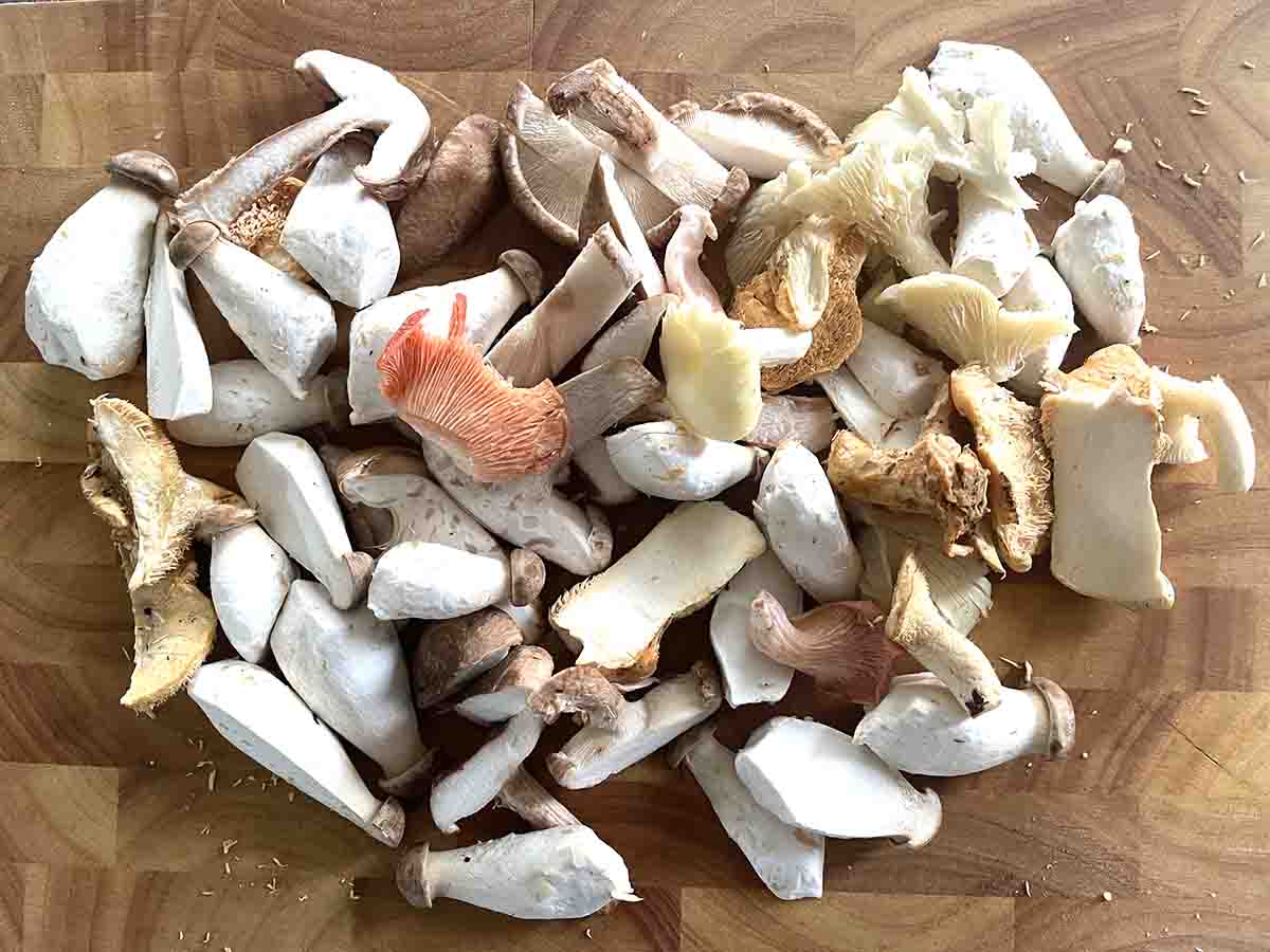 mixed chop mushrooms on a board.