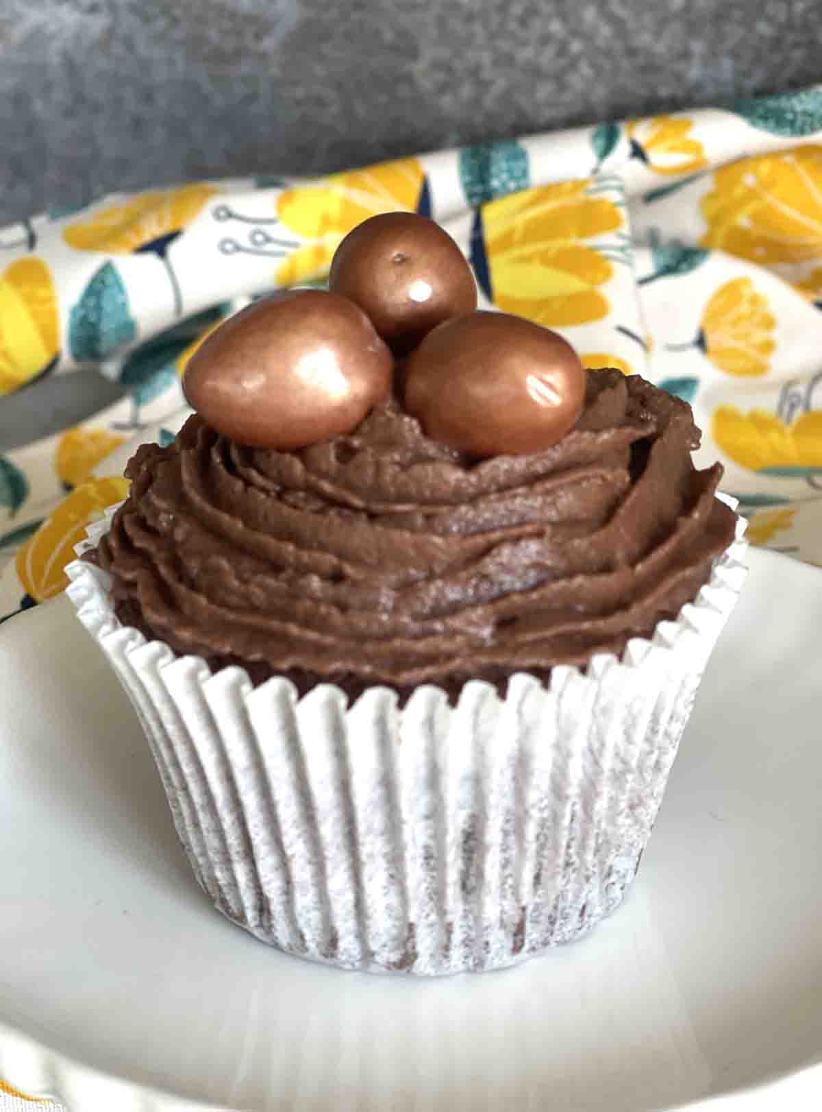 close up if a mini egg cupcake with bronze eggs on top.
