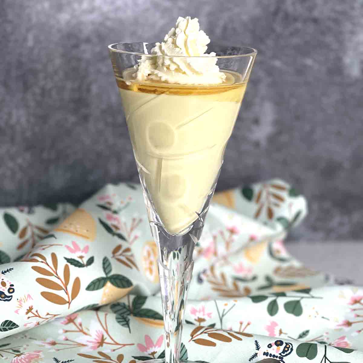 flummery dessert in a glass with cream on top.