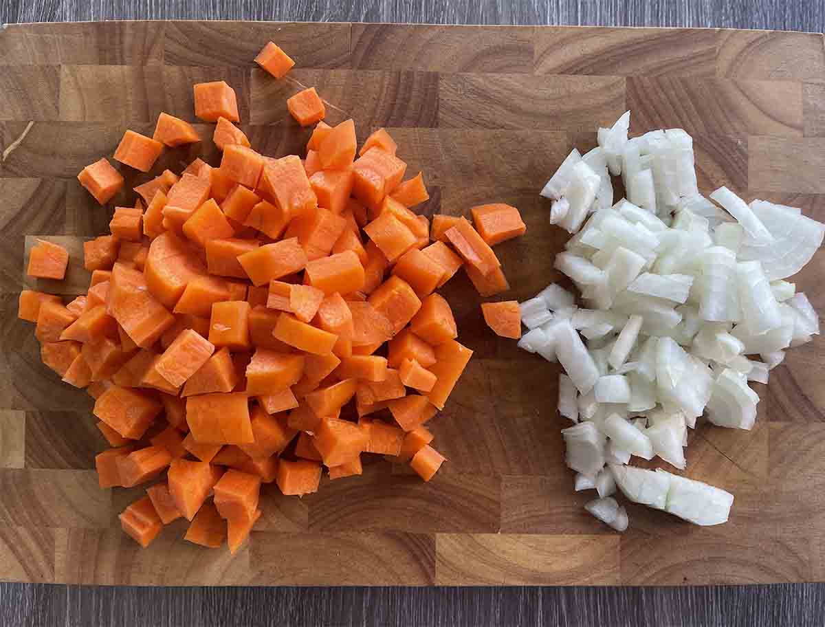 chopped carrots and onions on a board.