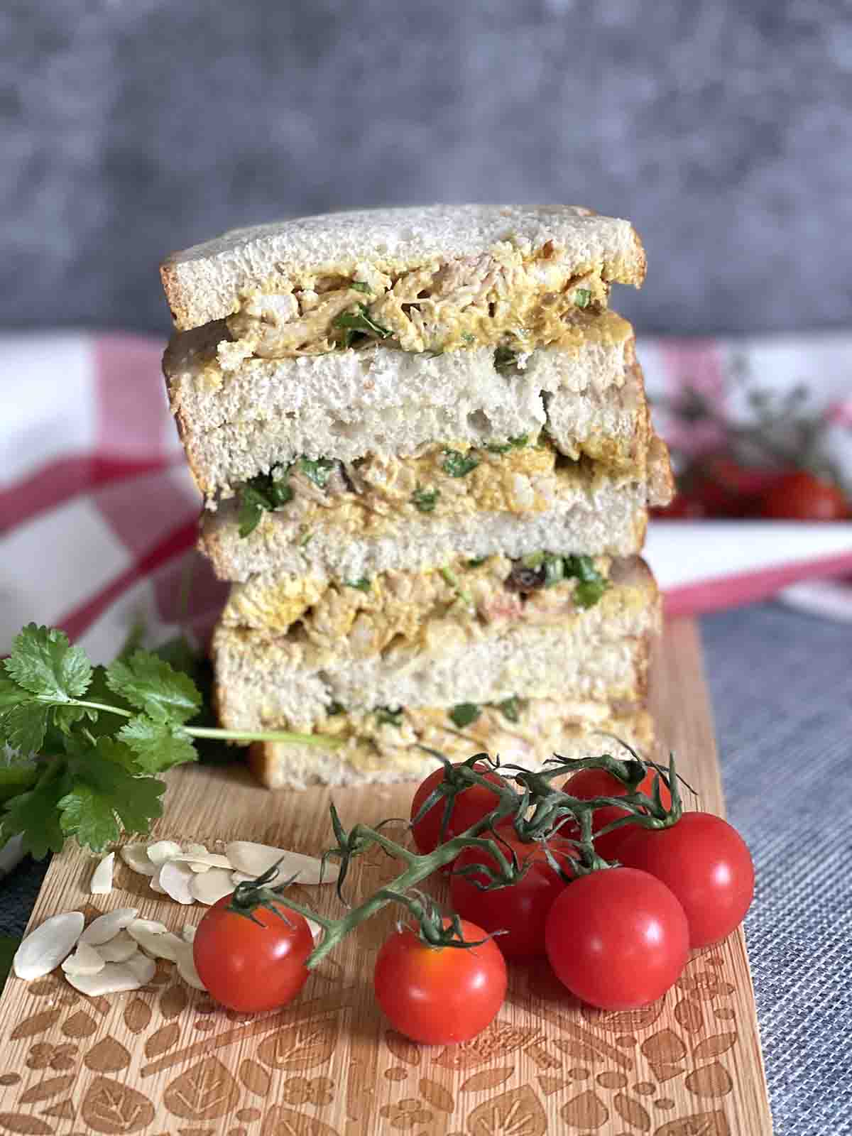 coronation chicken sandwich stacked on a board.