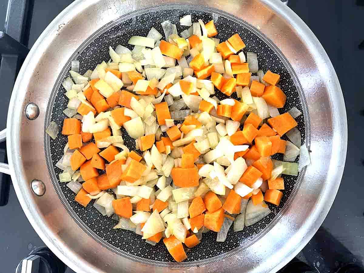 carrots and onions in a frying pan.
