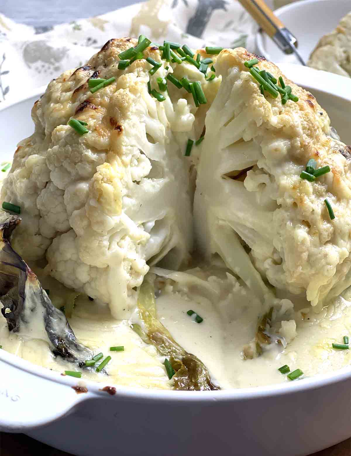 whole roasted cauliflower with portion cut.