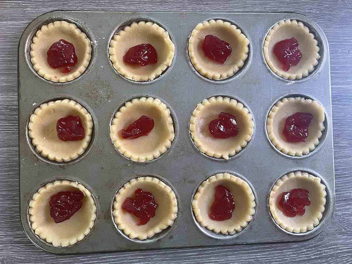 pastry in tart tin with jam at the bottom.