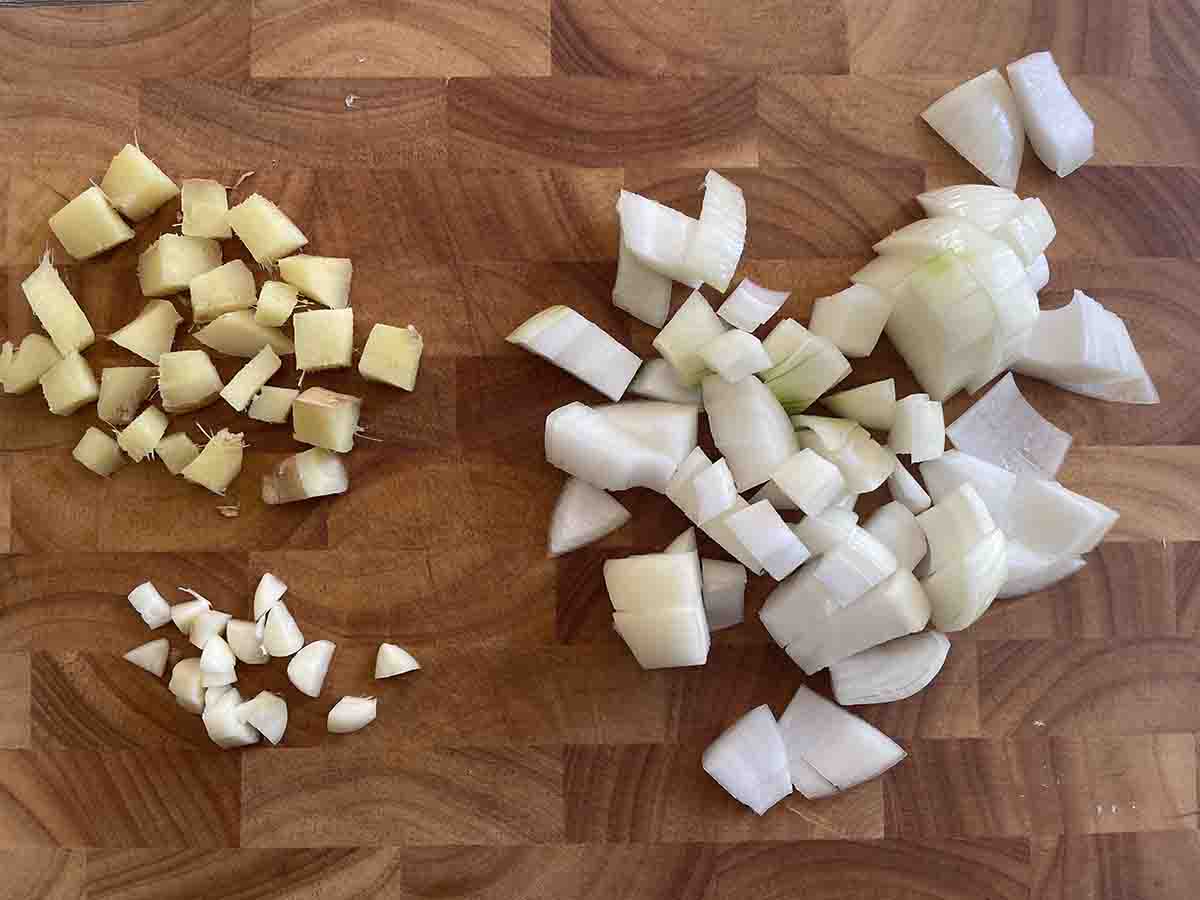chopped garlic, ginger and onion on a board.
