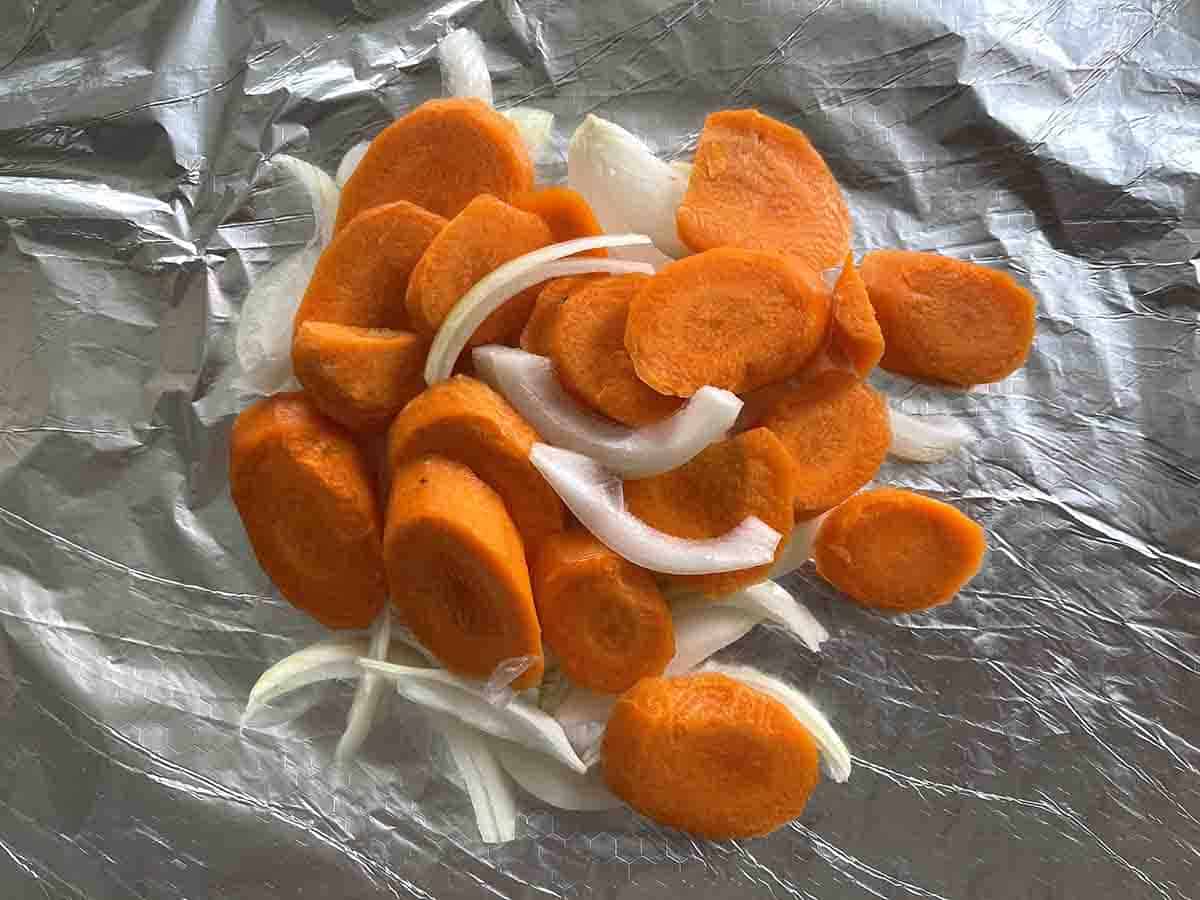 carrots and onions on a foil square.