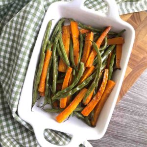 roasted green beans and carrots in a dish.