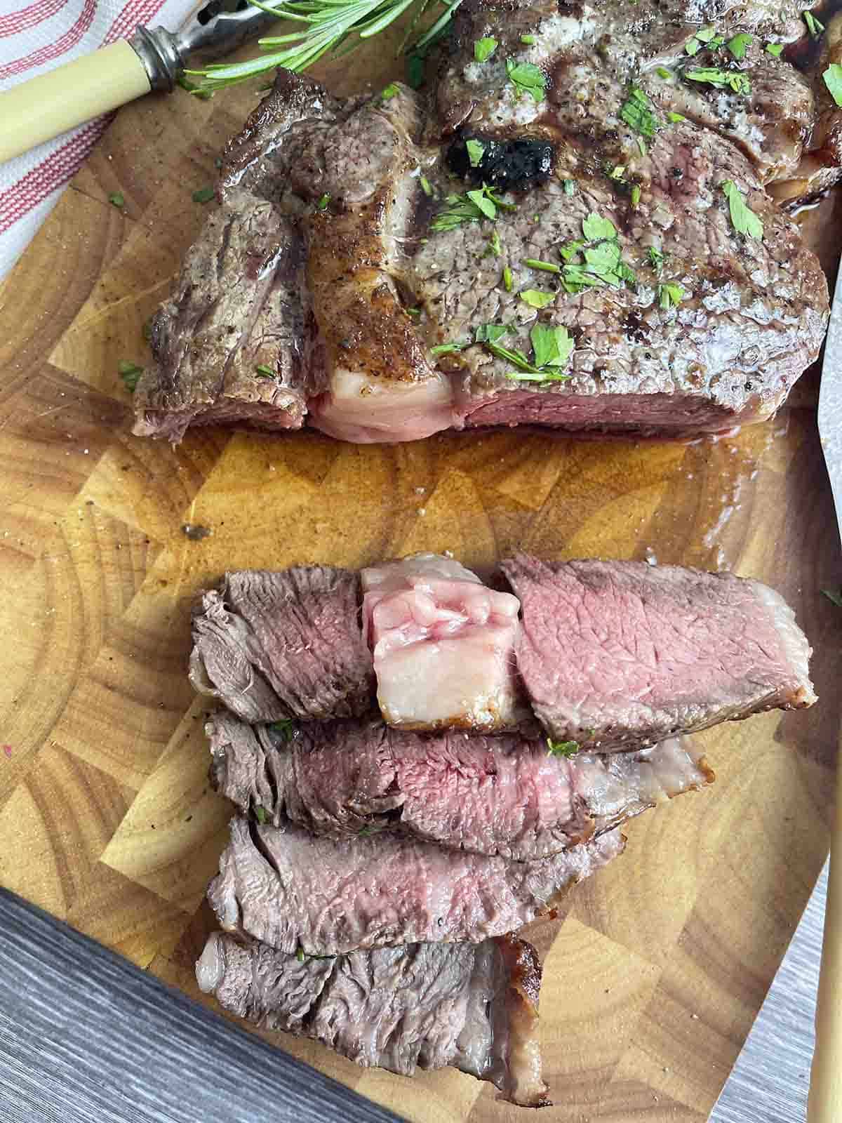 cooked steak cut on a board.