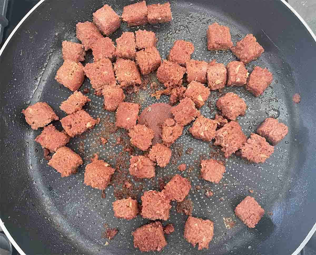 beef frying in pan.