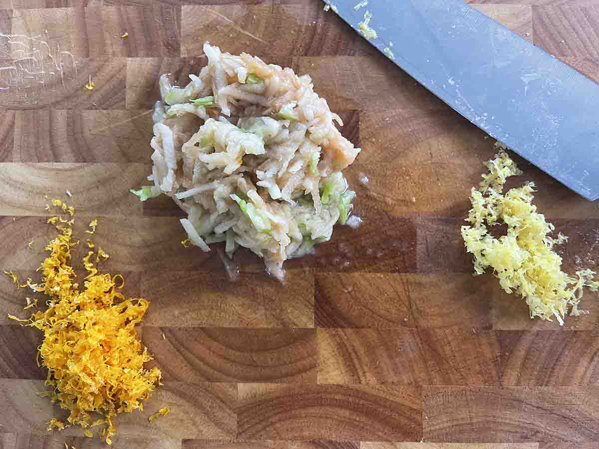 grated apple and citrus zest on a board.