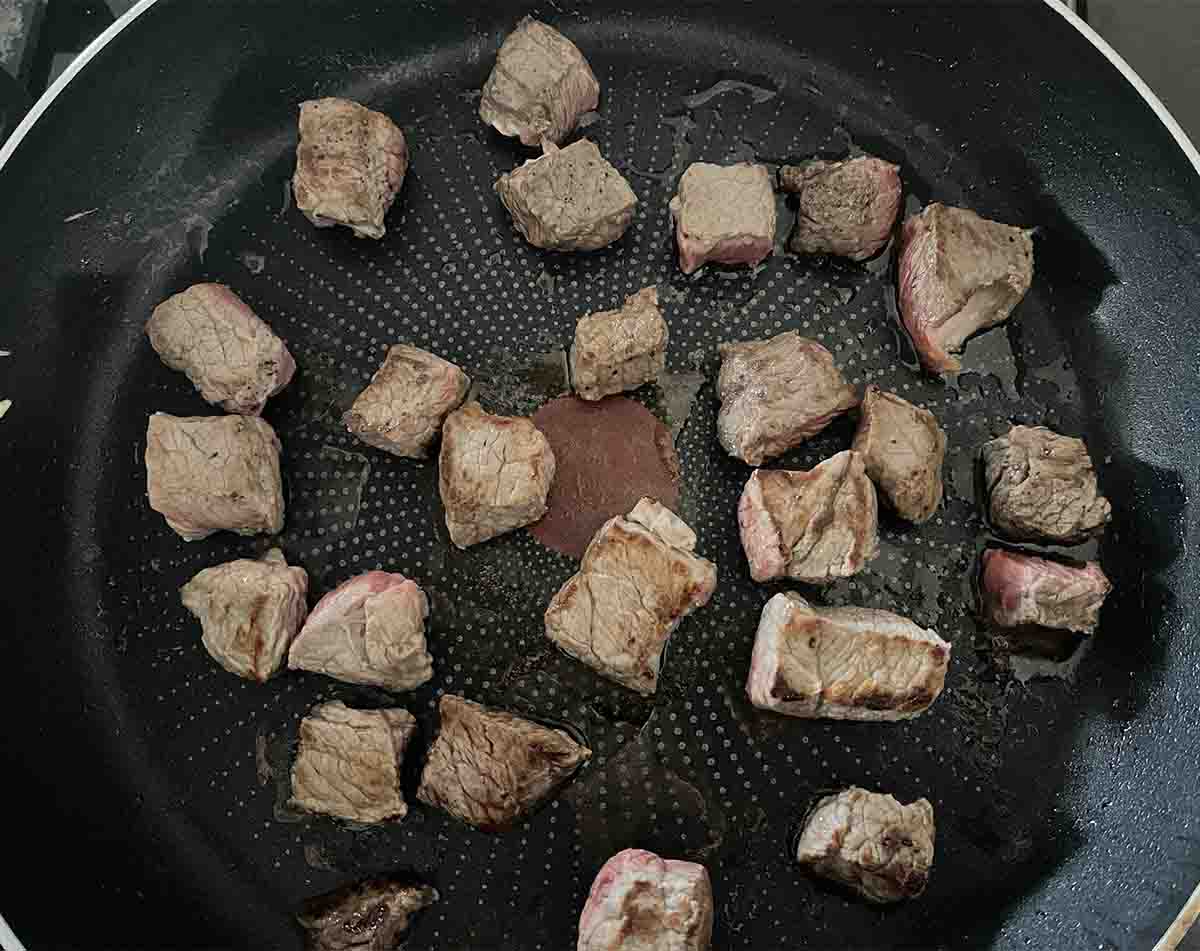 beef searing in a pan.