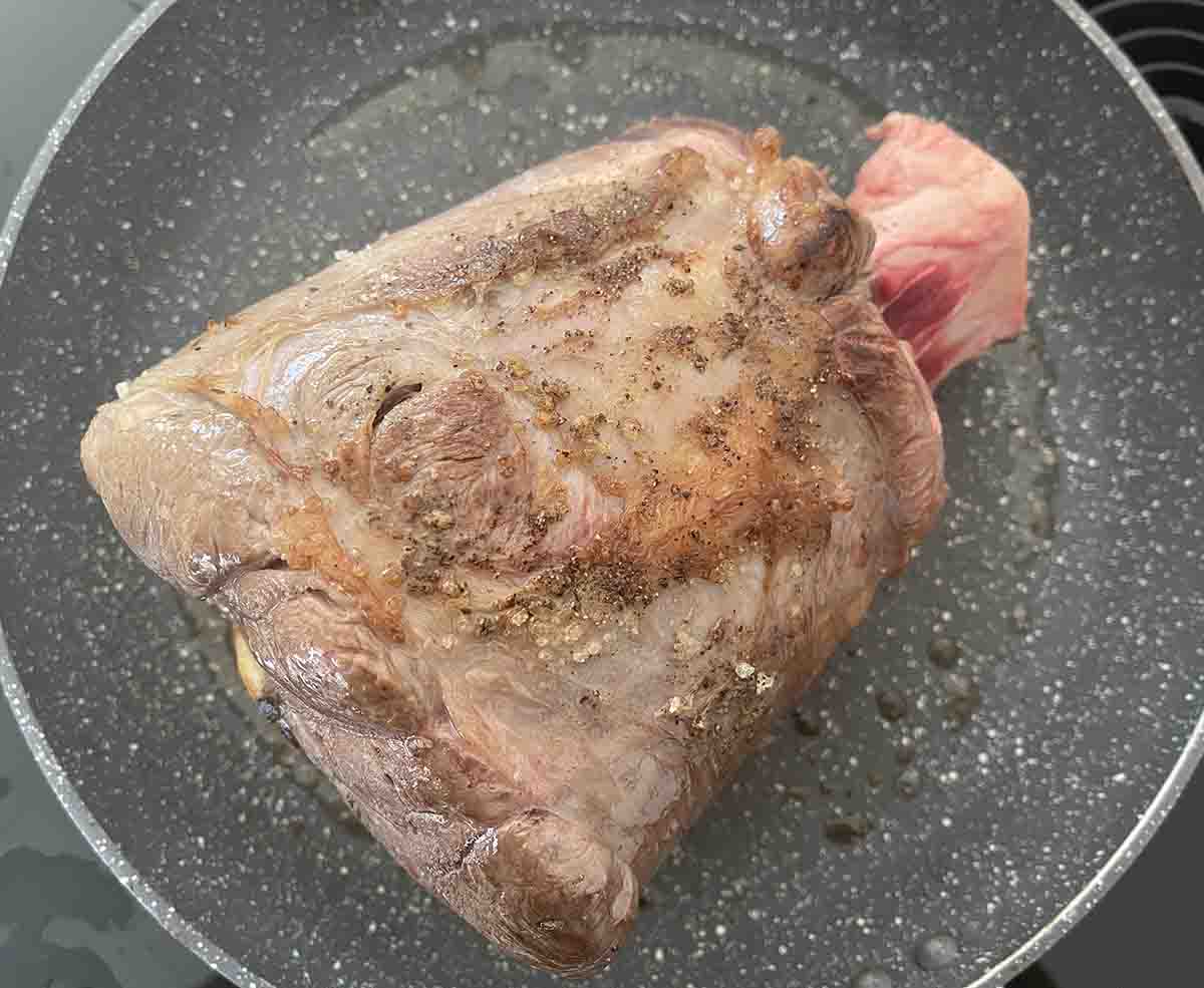 shin of beef searing in a pan.
